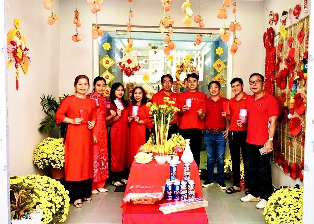 Đội ngũ HTX Đại Việt mặc áo đỏ chụp ảnh chung trước văn phòng dịp Tết